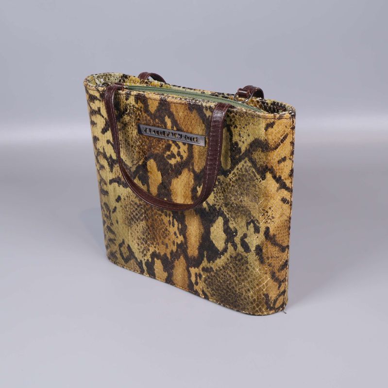 Ormmönstrad väska med bruna handtag från annan vinkel