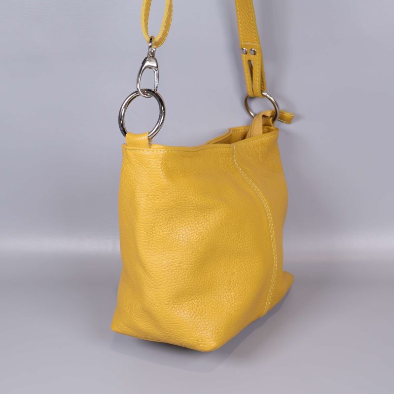 Sida av gul väska med metallring och axelrem