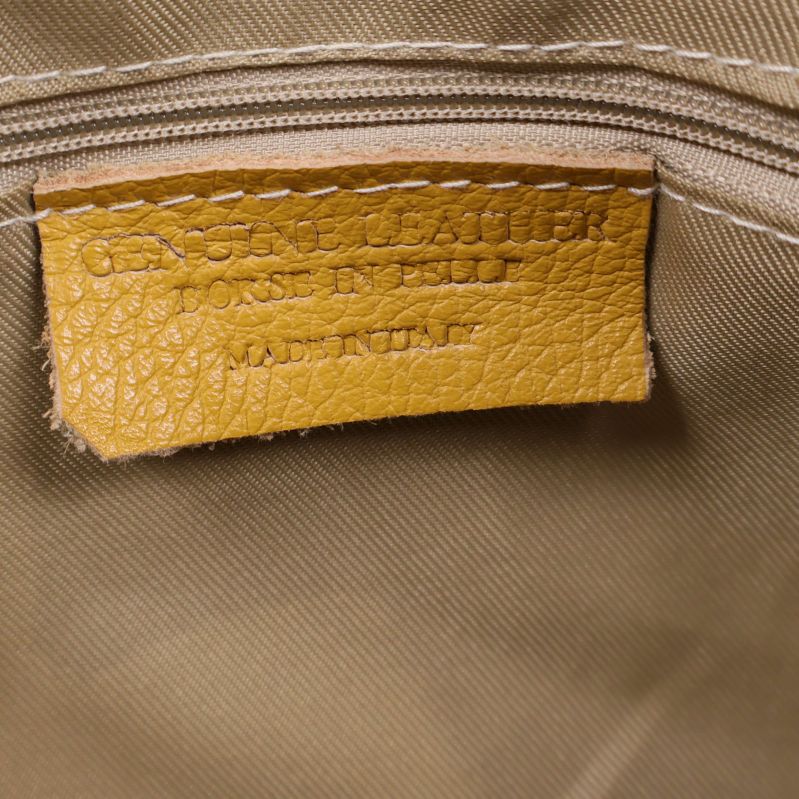 Närbild på etikett i väska med text genuine leather och made in Italy