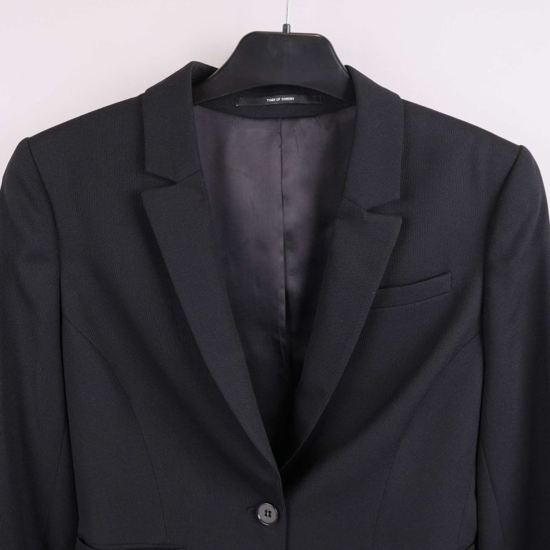 Närbild av krage, axlar och bröst på svart kavaj