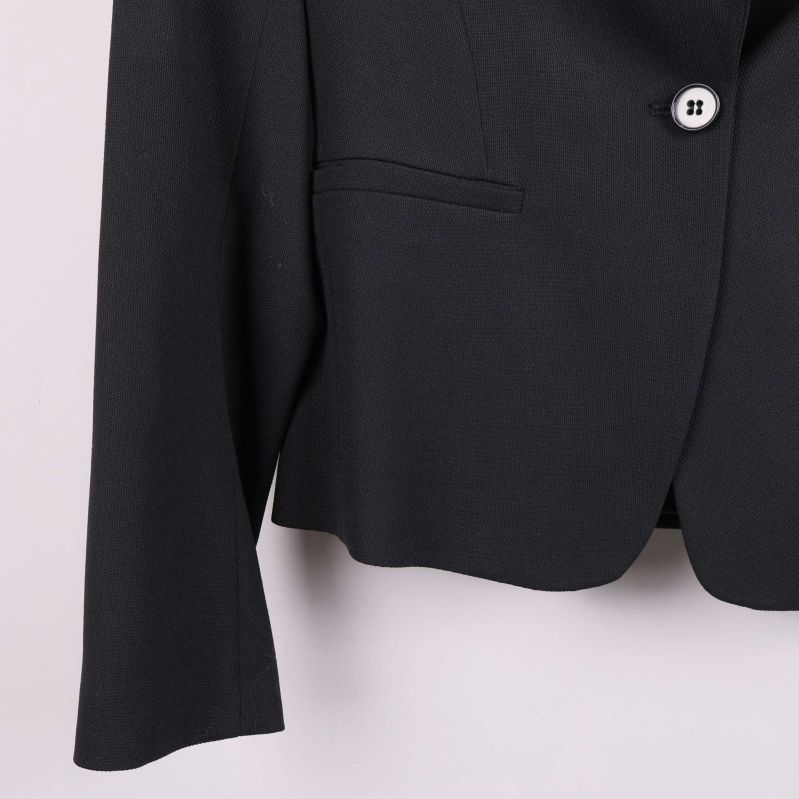 Närbild av kavajens nedre del och en knapp framtill