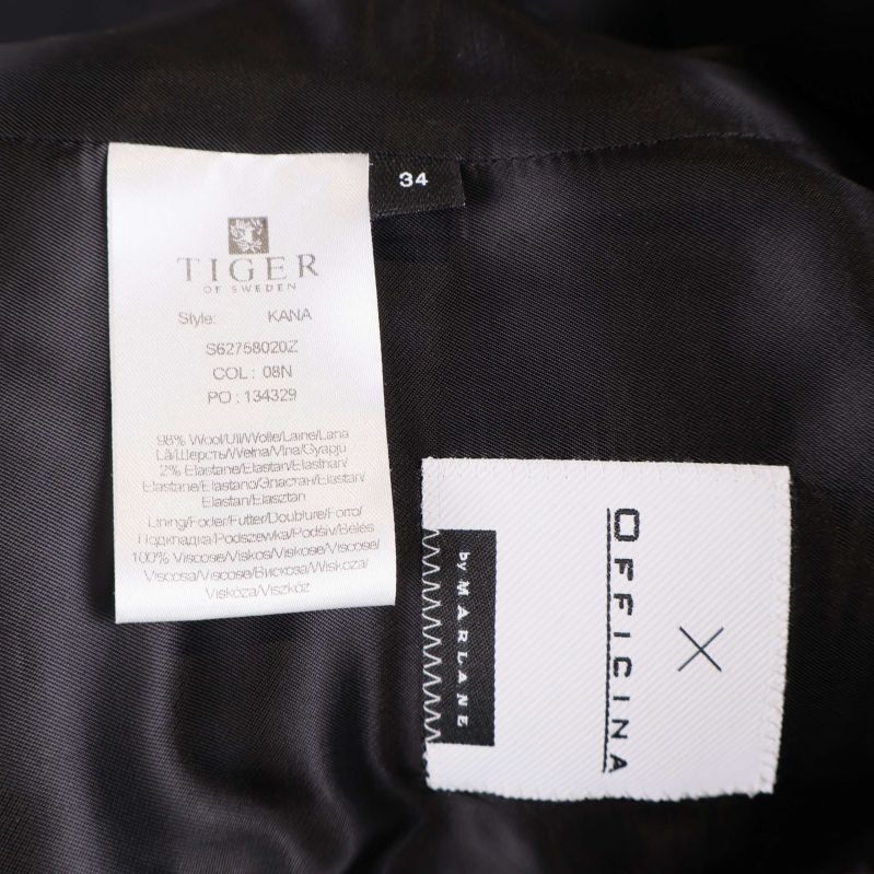 Etikett med materialinformation och storlek 34 i svart kavaj