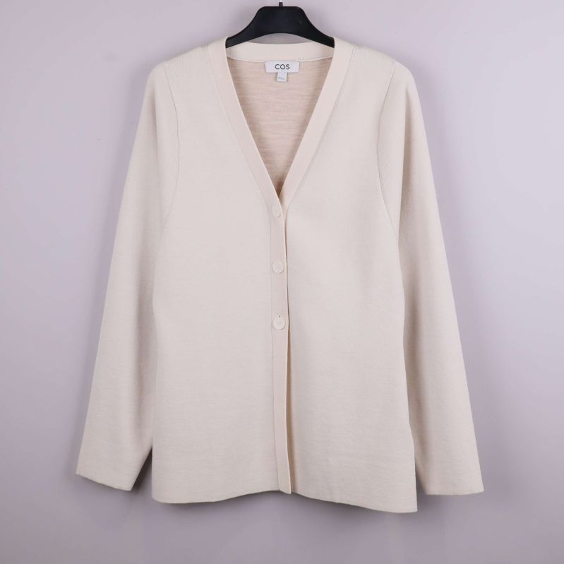 Beige cardigan med V-ringning och knappar på galge, framifrån