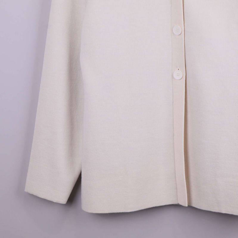 Nedre delen av beige cardigan med knappslå och sprund