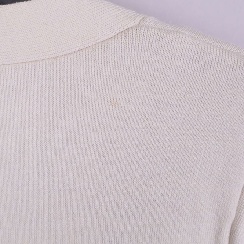 Närbild på axelparti på beige cardigan med liten svag fläck