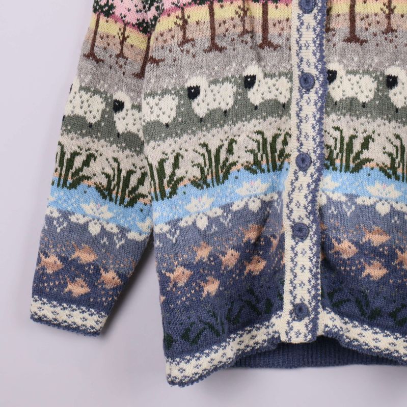 Nederdel av kofta med stickat fiskmotiv och vågmönster i blå nyanser