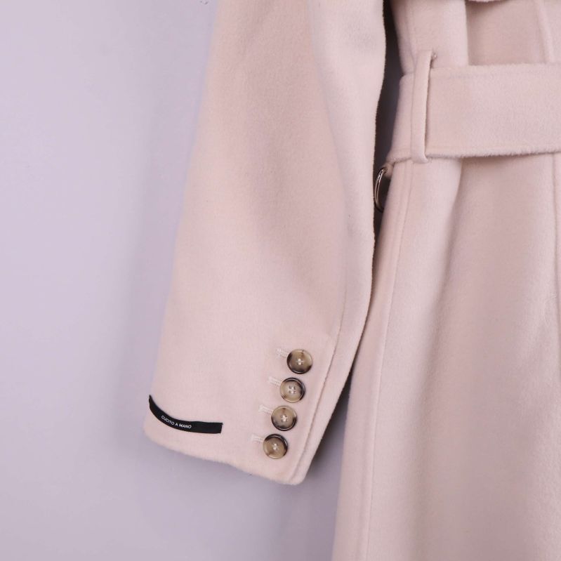 Ärmslut med fyra knappar på beige kappa