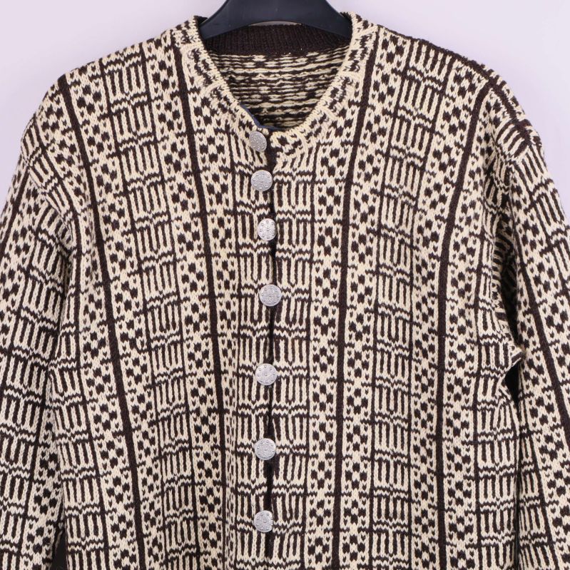 Närbild på koftans framstycke och silvriga knappar