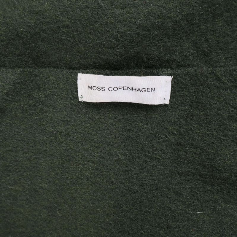 Närbild på Moss Copenhagen-etikett på grön halssjal