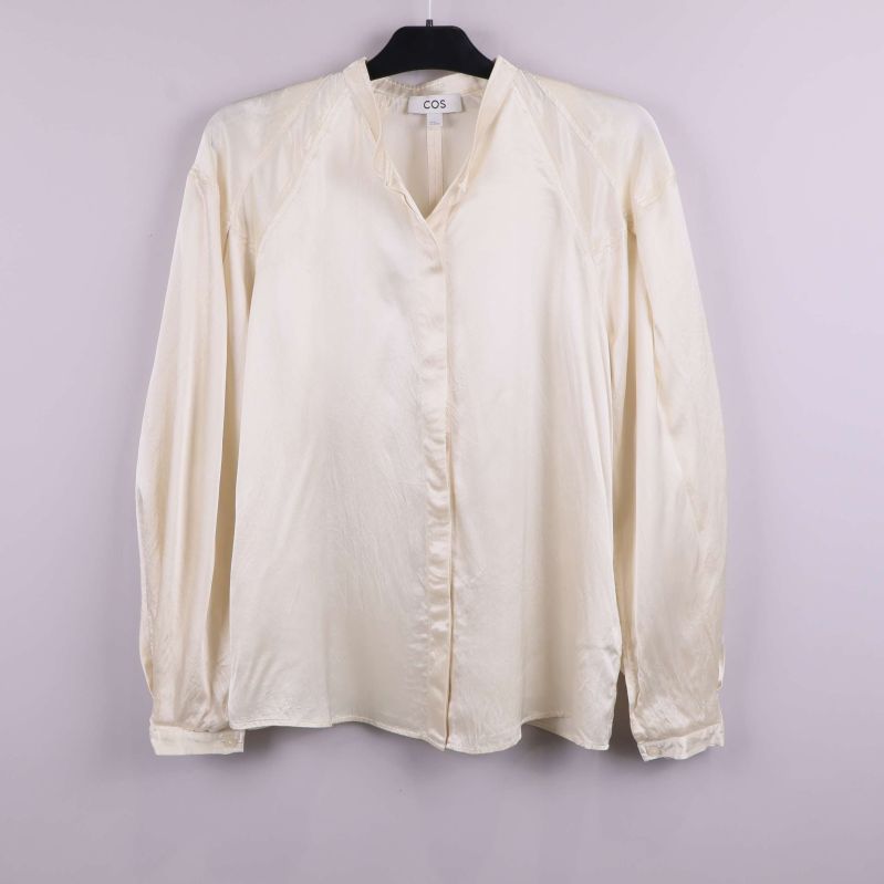 Ljus blus med lång ärm framifrån på galge