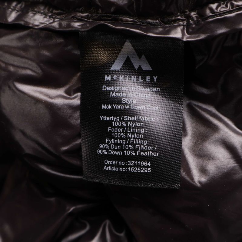 Materialetikett som visar dunfyllning och tygmaterial på jacka