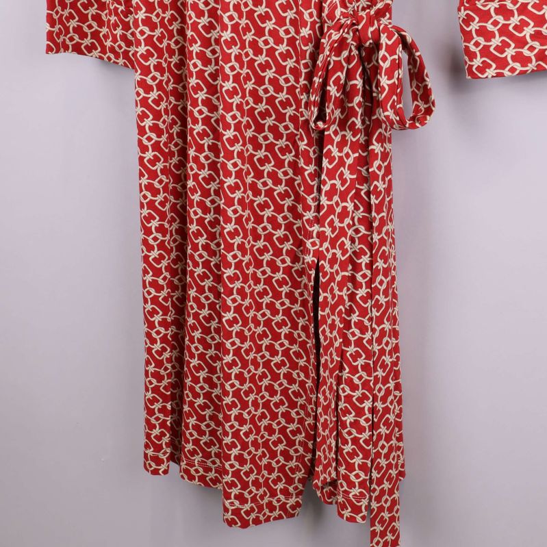 Närbild på nederdelen av röd kimono med knytband