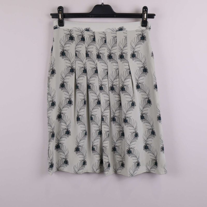 Plisserad kjol med ljust tyg och mörka fjädrar