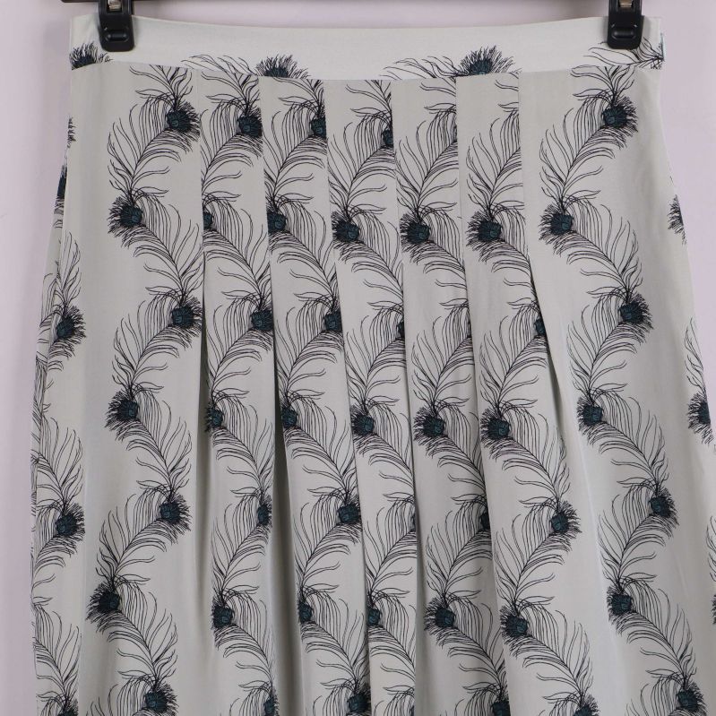 Detaljbild på plisserad kjol med fjädermönster