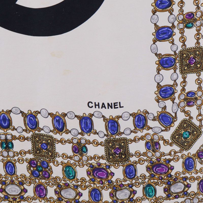 Närbild på Chanel-text och smyckestyck i hörnet