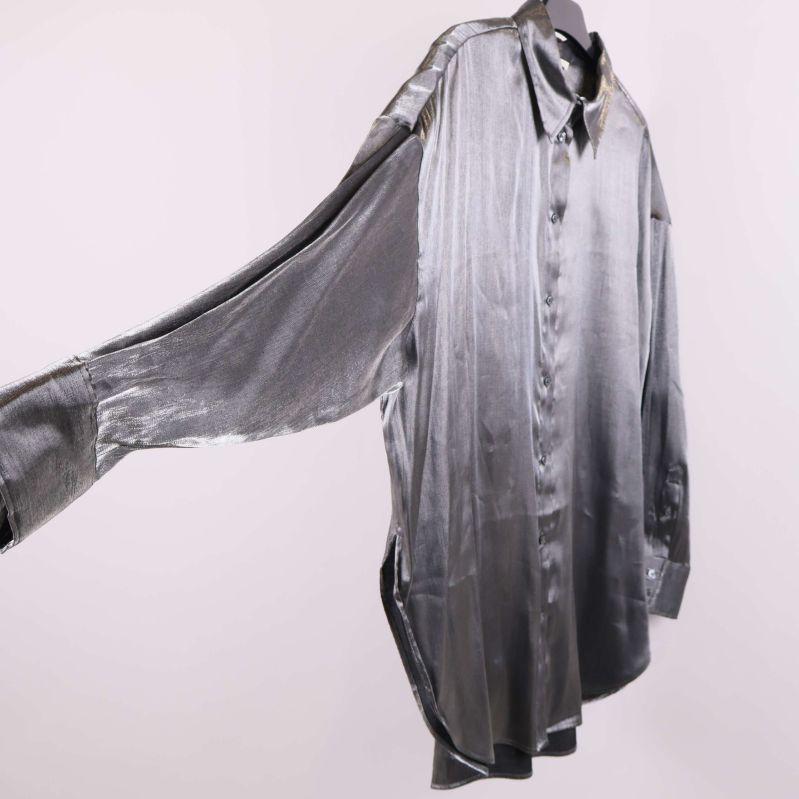 Sidan av skjorta med lång ärm och glansigt tyg i fokus