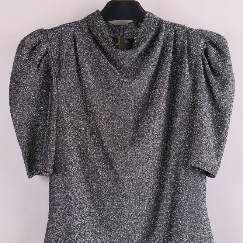 Närbild på överdel av glittrig topp med puffärm