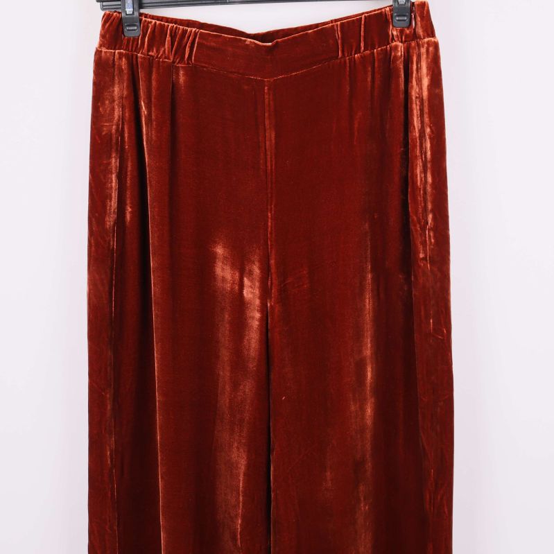 Närbild på vida ben och sammetsstruktur hos byxorna