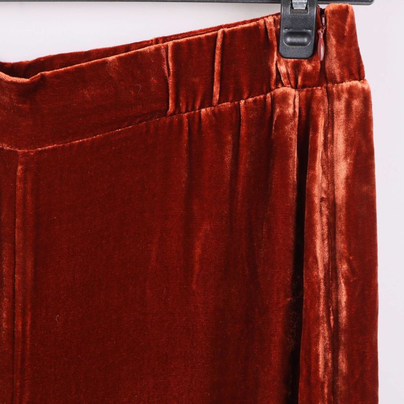 Närbild på sammetsbyxans midjedetalj i rostbrun färg