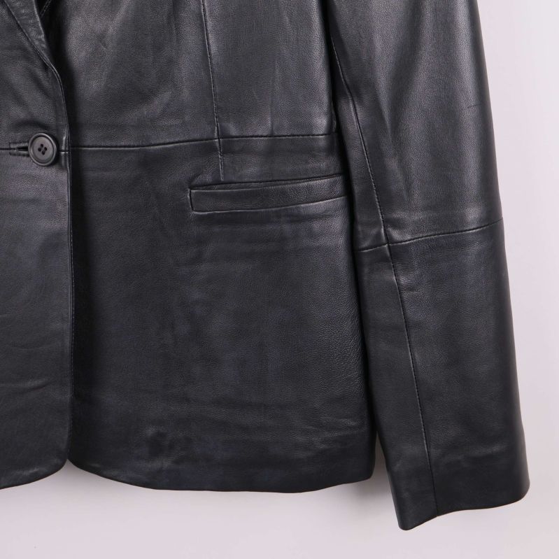 Närbild på fickor och nederdel av svart skinnkavaj