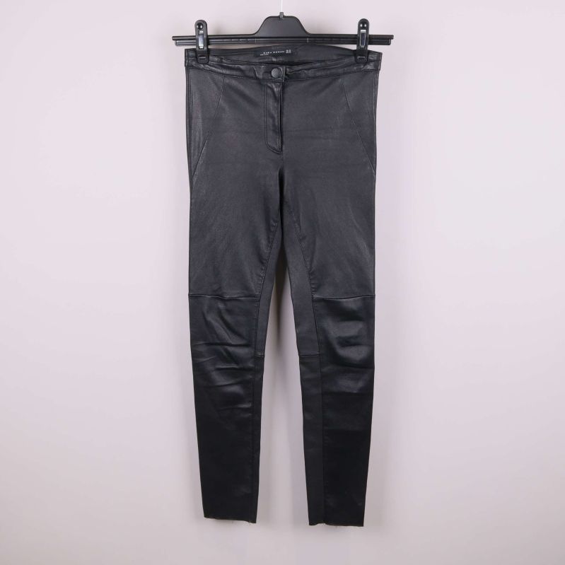 Framsida av svarta byxor med läderlook på galge