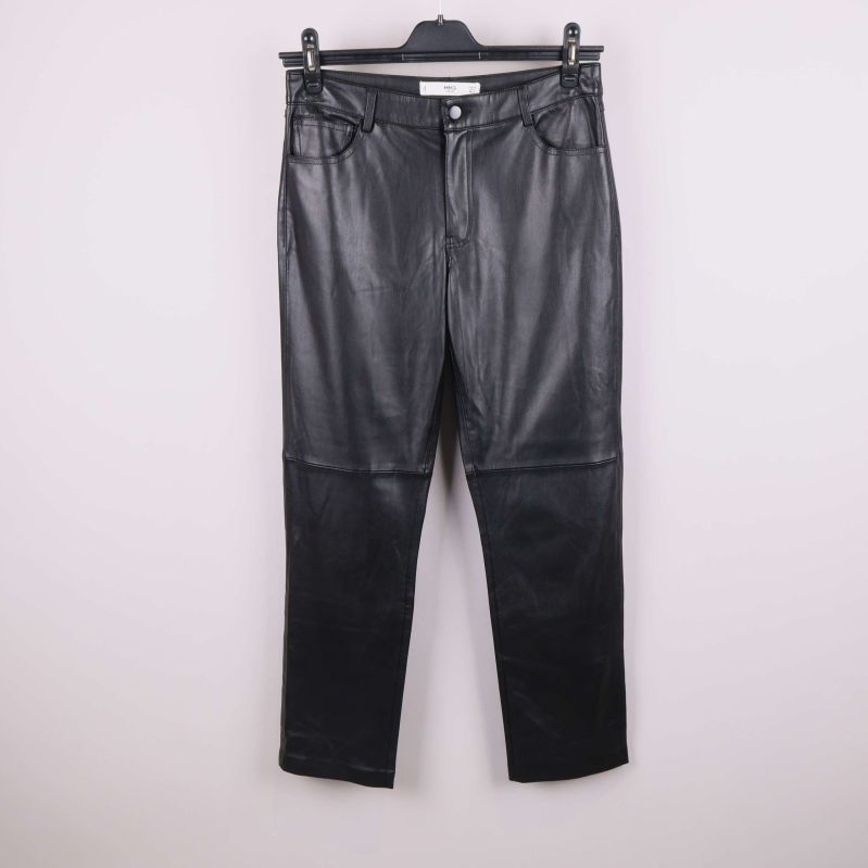 Svarta byxor i konstläder fotograferade framifrån på galge