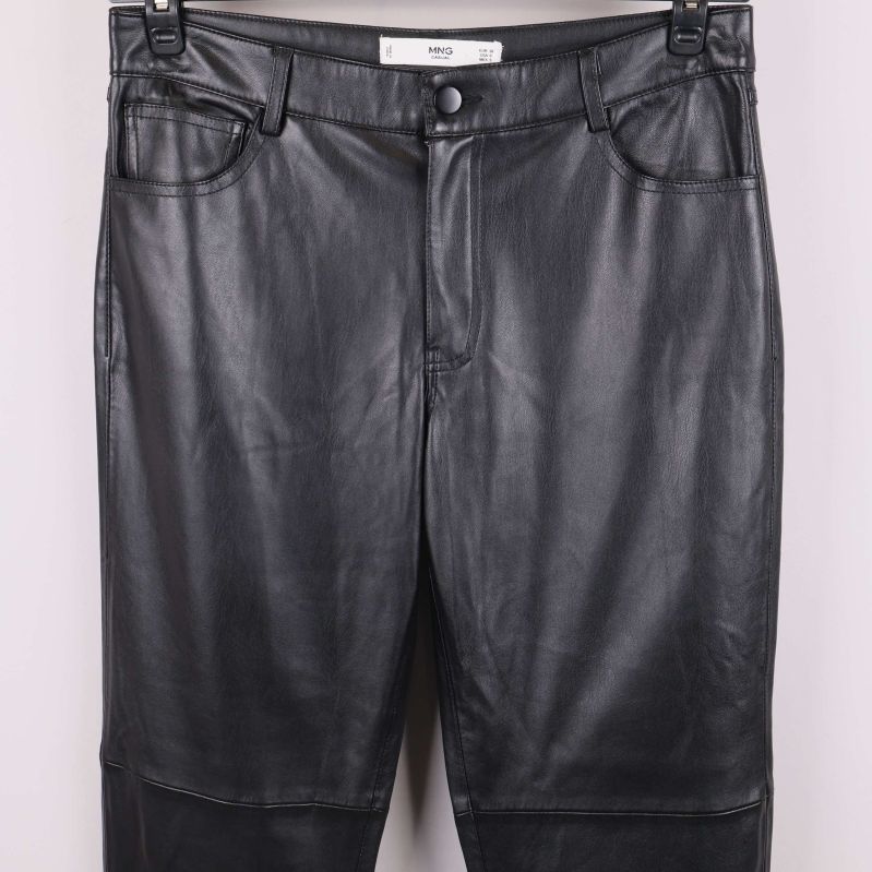 Närbild på framfickor och knapp på svarta konstläderbyxor