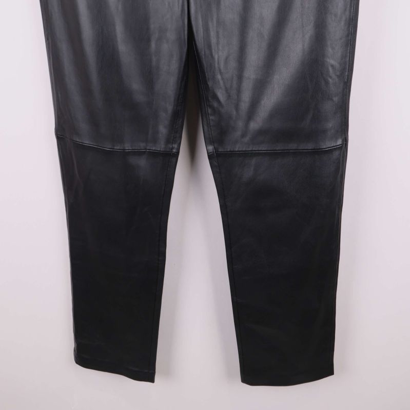 Nedre delen av benen på svarta konstläderbyxor