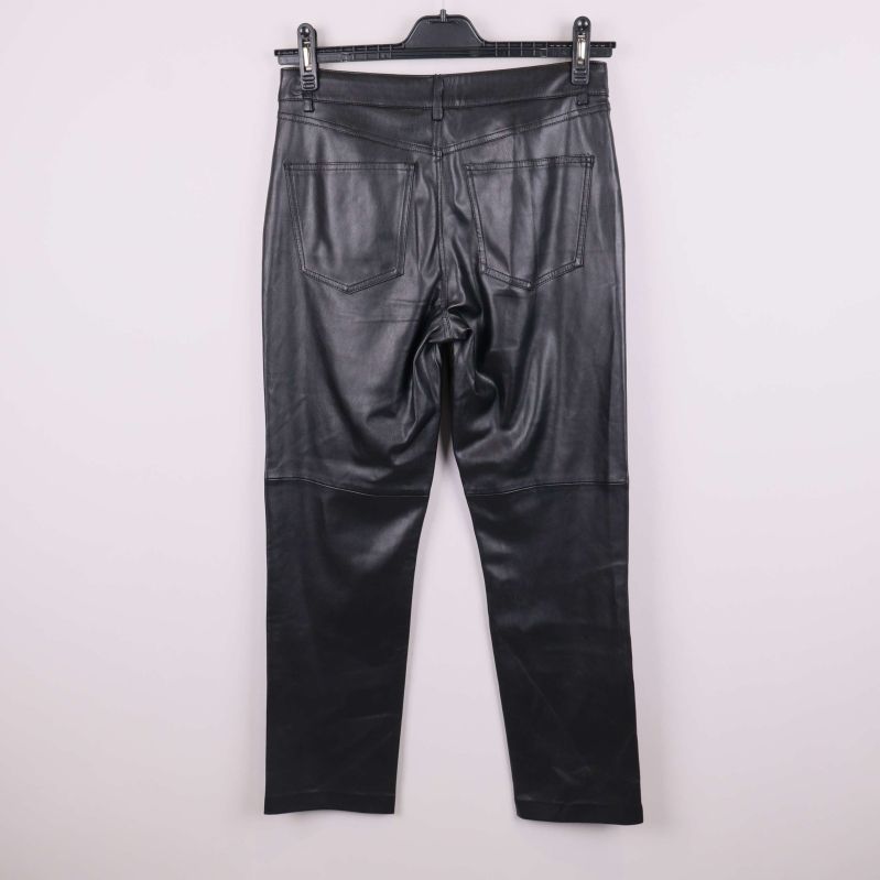 Svarta byxor i konstläder fotograferade bakifrån på galge