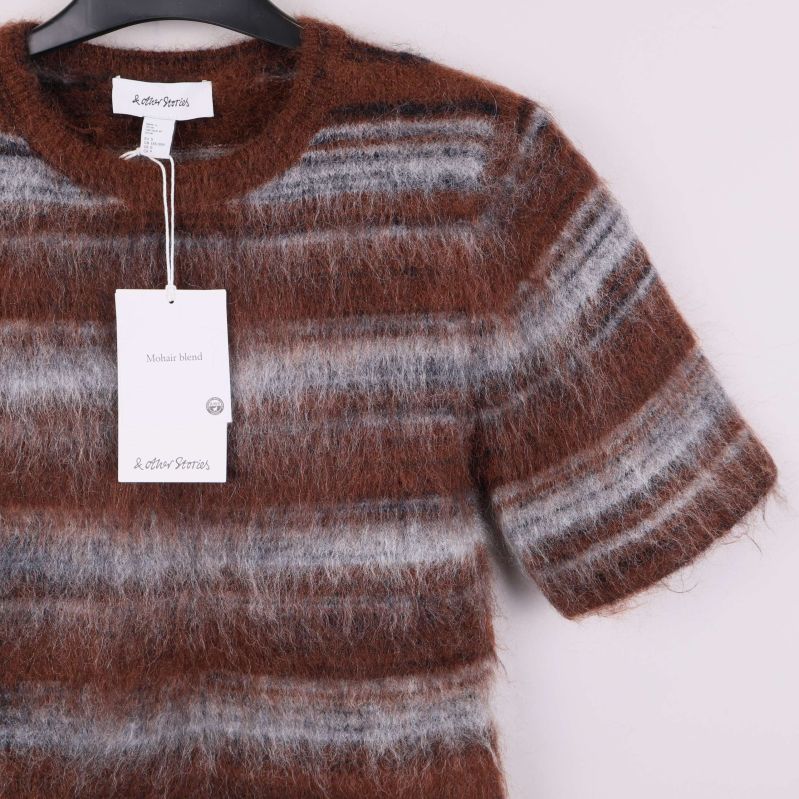 Detalj av ärm och etikett på kortärmad brun randig topp