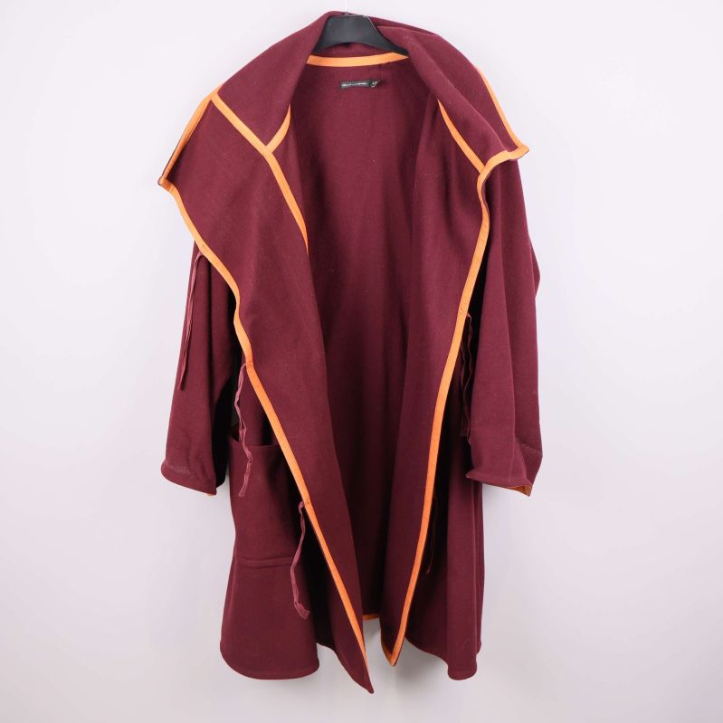 Jacka uppknäppt med orange kantband längs hela öppningen