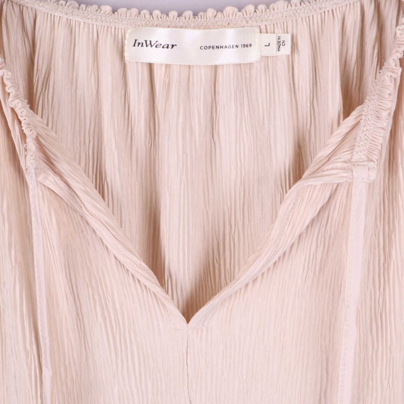 Detalj av v-ringning och InWear-etikett