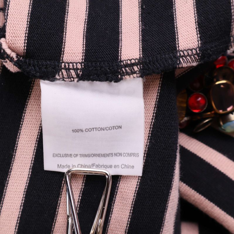 Materiallapp som visar 100% bomull på randigt tyg