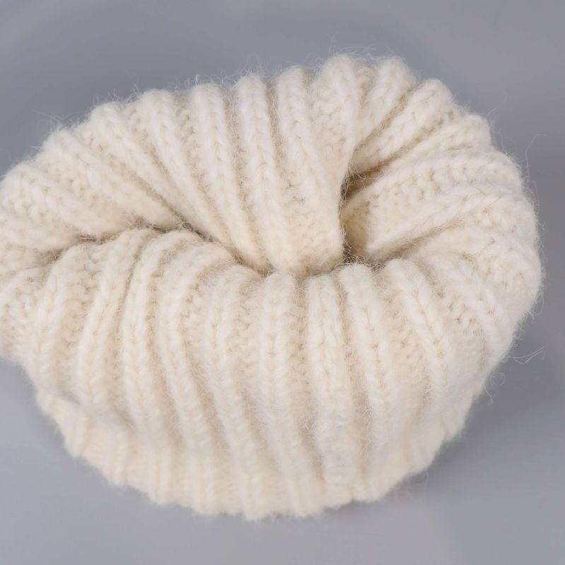 Insidan av krämvit ribbstickad mössa visas