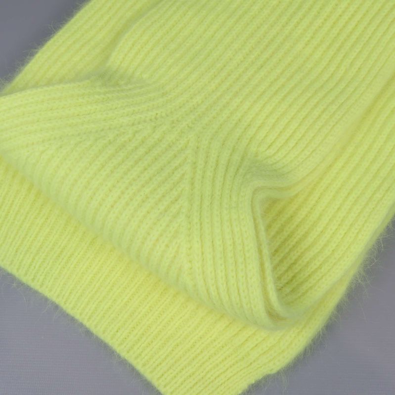 Närbild på ribbstickad struktur i gul halsduk