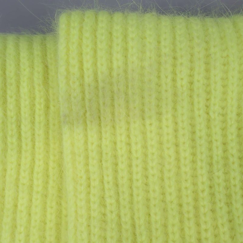 Gul halsduk med tät ribbstickad yta i närbild