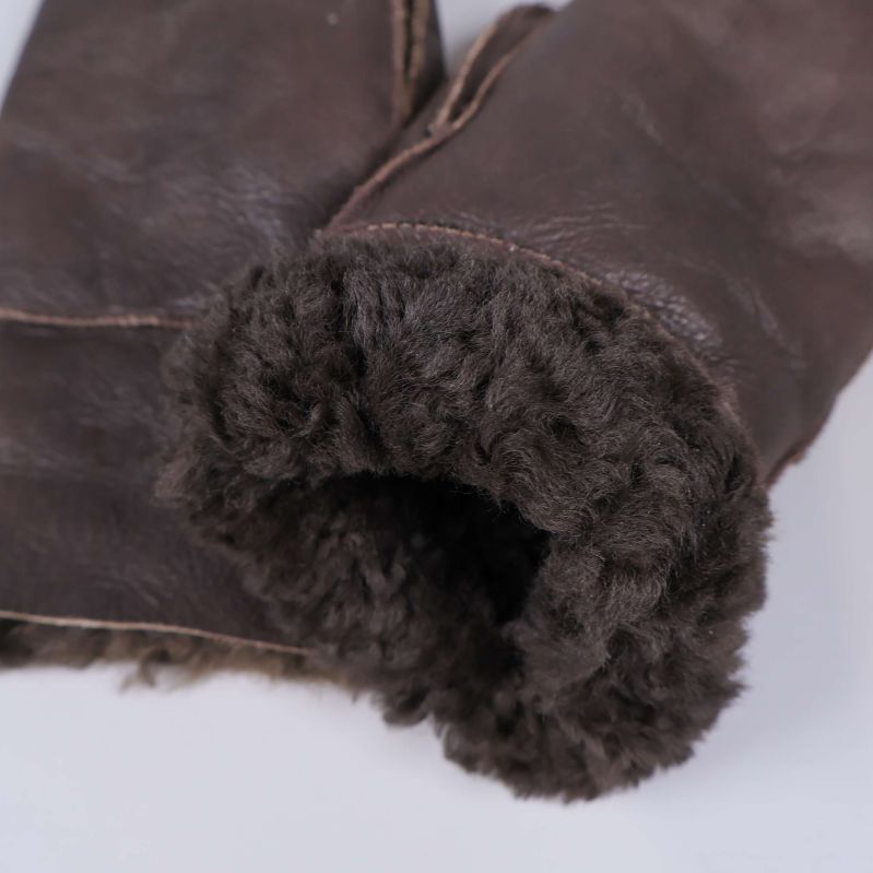 Närbild på fårullsmudd av brun vante