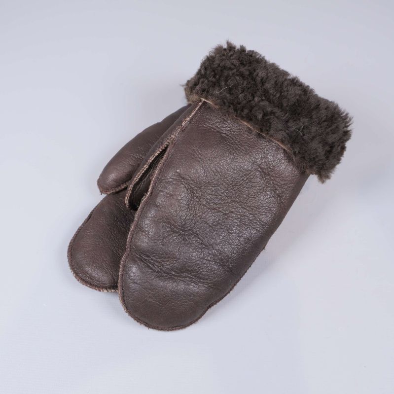 Bruna vintervantar med fårullskant liggande på vitt underlag