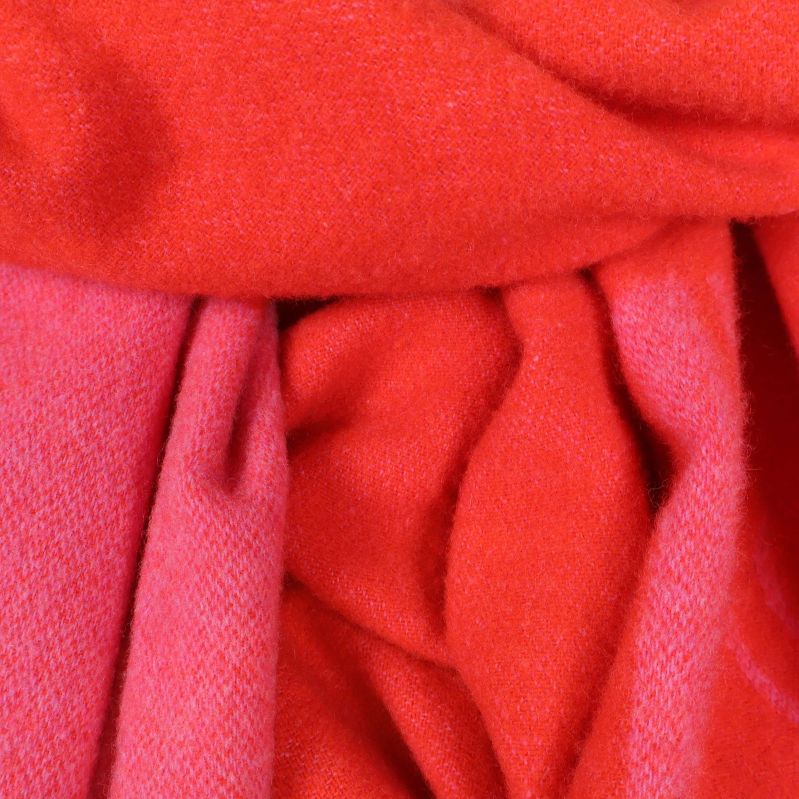 Närbild på material och struktur i rosa och orange halduk