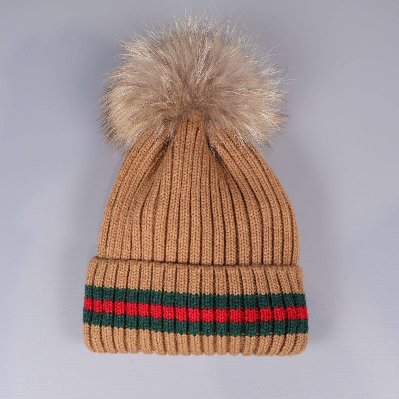 Beige ribbstickad mössa med fluffig tofs