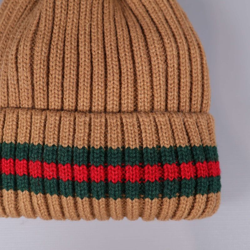 Närbild av randigt uppvik på beige mössa