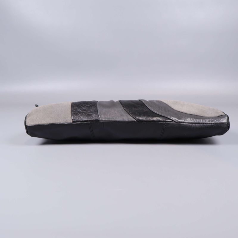 Botten på clutch med skinnpaneler i svart och grått