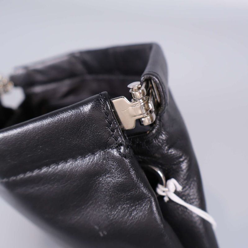 Detalj av silverfärgad öppningsmekanism och sömmar