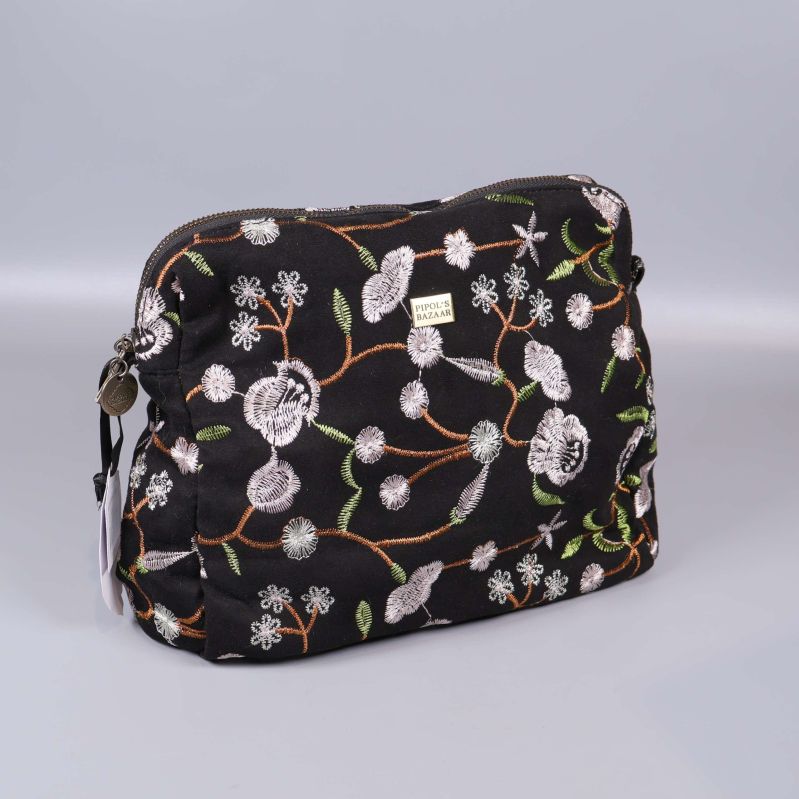 Necessär med svart bakgrund och broderade vita blommor