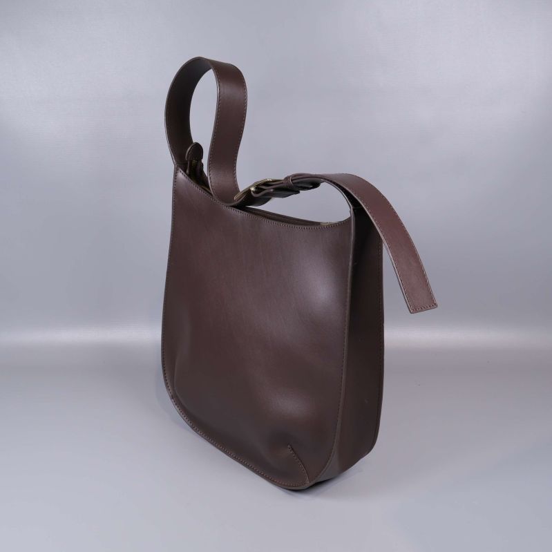 Sned vy på brun axelremsväska i läder med stadigt axelband