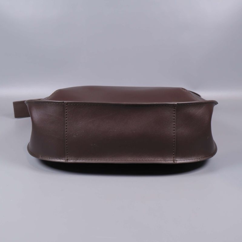 Botten av brun axelremsväska, visar sömmar och stabilitet