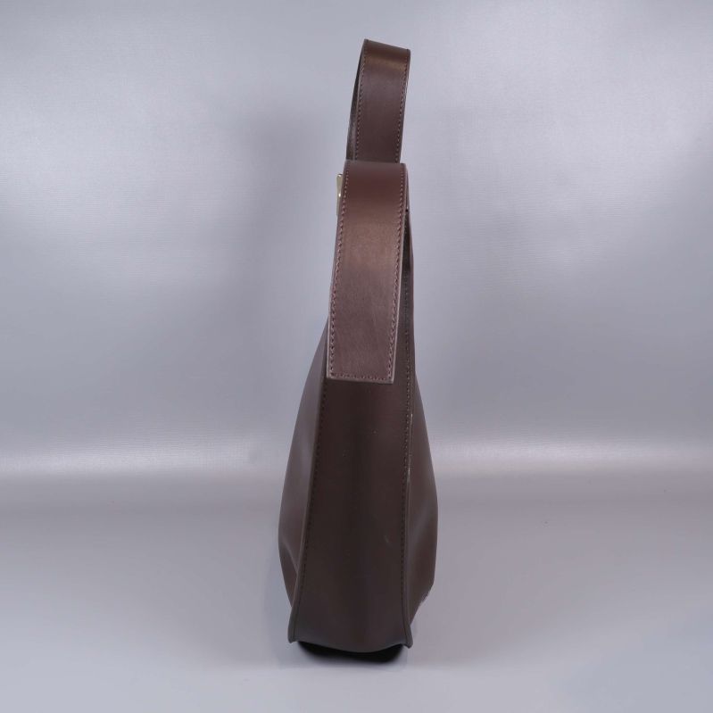 Sido vy av brun axelremsväska i läder med sömmar