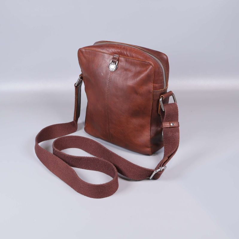 Axelremsväska i brunt läder med justerbar rem sedd snett framifrån