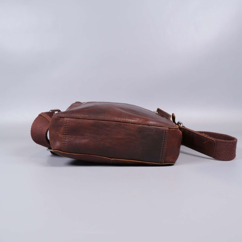 Brun axelremsväska i läder liggande med sidorna synliga