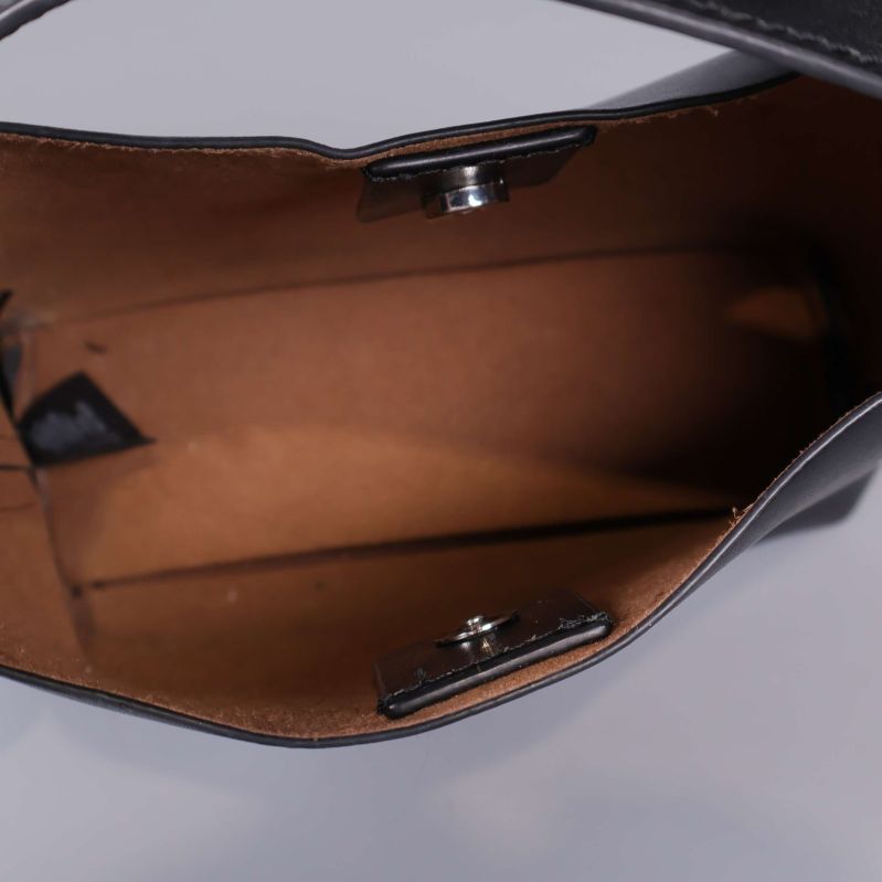 Insidan av svart väska med brun innersida och magnetlås